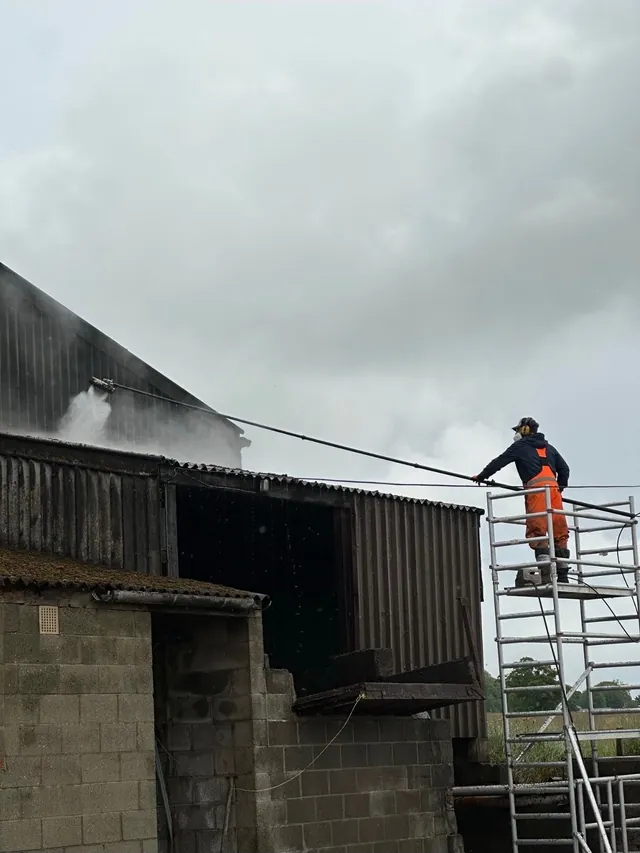 Cleaning an outbuilding roof from a scaffold tower